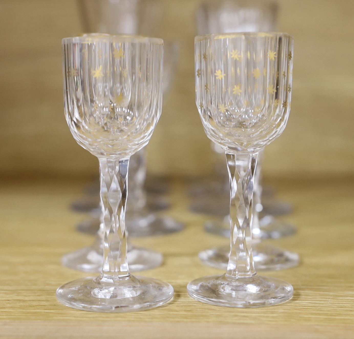 A collection of seventeen late 18th century drinking glasses, consisting of a set of four facet cut stemmed wines, a set of five small liqueurs with gilt star painted bowls and three various wine glasses (12)